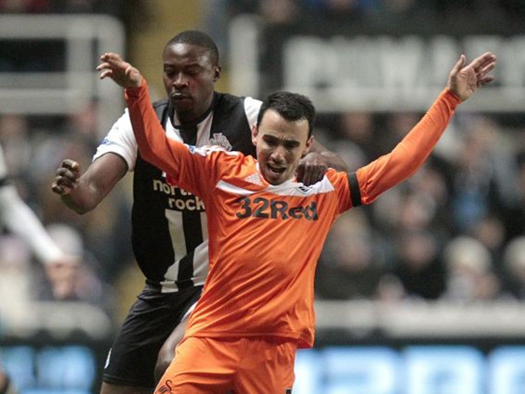Swansea's Leon Britton (front) is challenged by Newcastle's Shola Ameobi