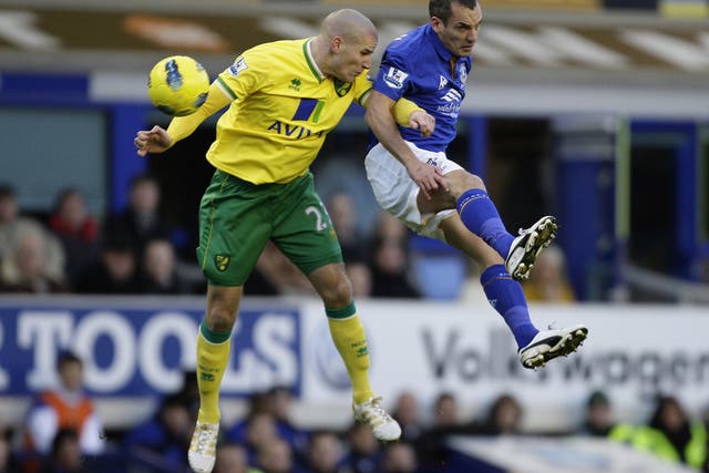 Everton scorer Leon Osman (right) jumps for the ball with Norwich's Marc Tierney