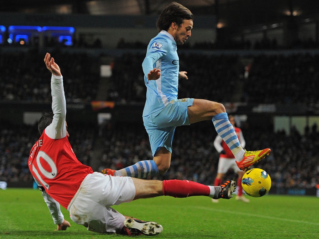 Manchester City's Spanish midfielder David Silva (R) vies with Arsenal's Dutch striker Robin van Persie