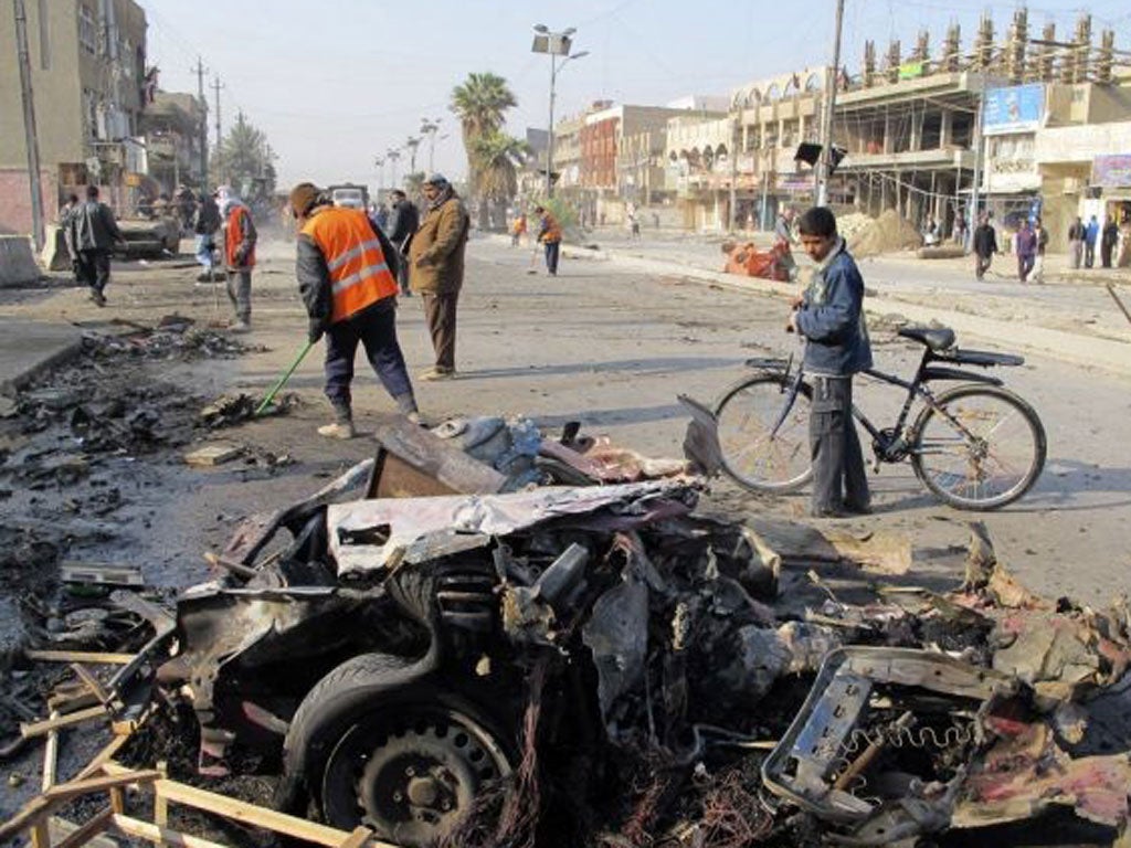 A boy stands near the site of a car bomb attack in Baghdad's Shaab District