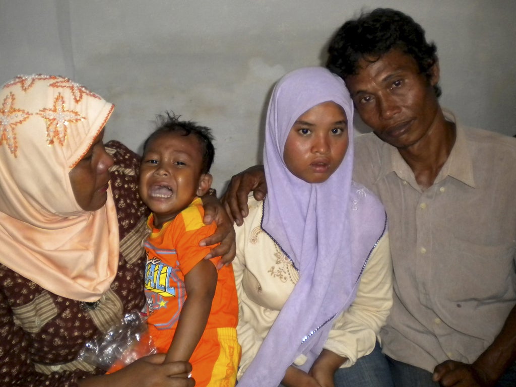 Fifteen-year-old Wati, second right, with her father Yusuf, right, mother Yusniar, left, and younger brother Aris. The teenager was forced into begging