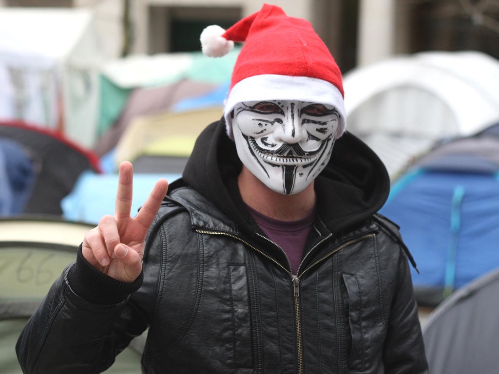 A masked Occupy London protester yesterday