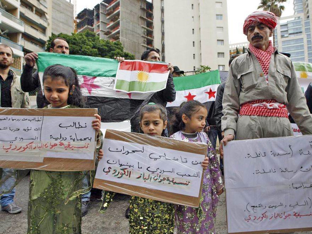 Syrian Kurd protesters carry placards agasnit Syrian president Bashar Assad during a protest outside the Arab League offices in Beirut, Lebanon