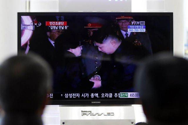 South Koreans watch a TV screen showing Kim Jong-un, right, greet the wife of former South Korean President Kim Dae-jung, Lee Hee-ho