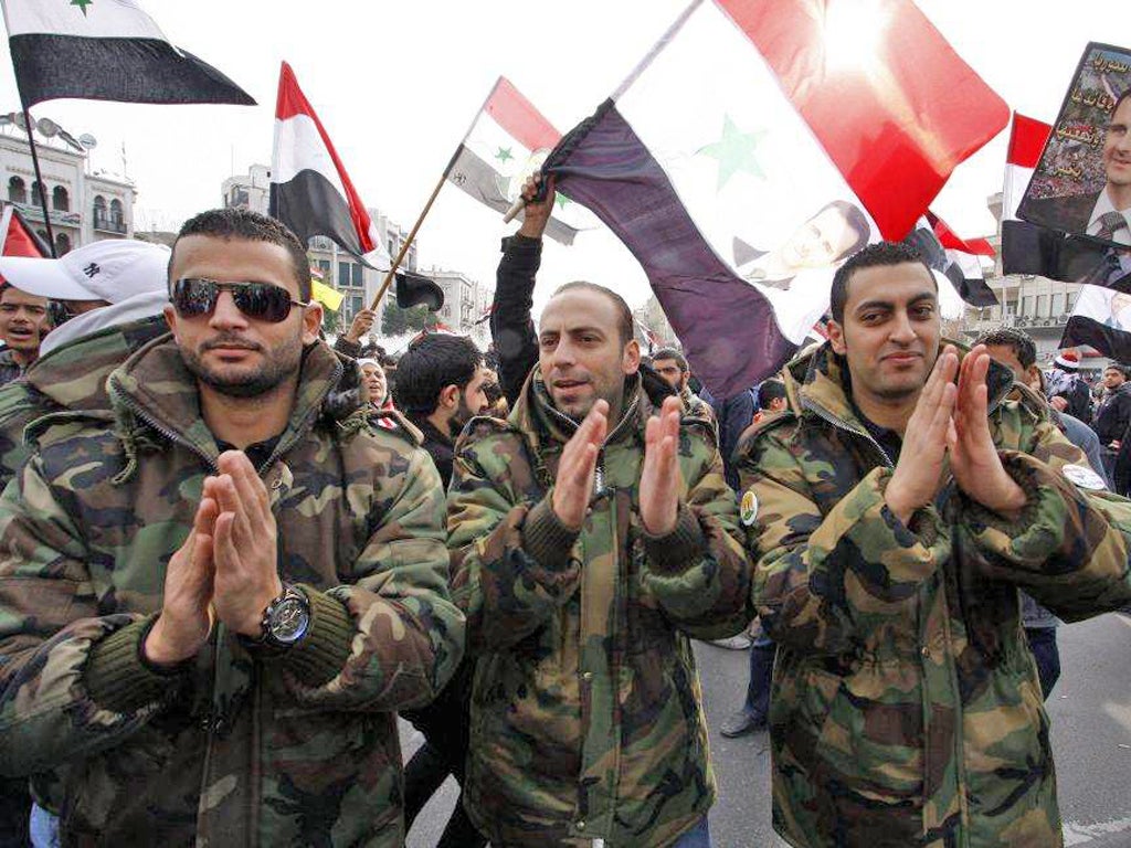 Syrian soldiers chant slogans during a pro-regime rally in Damascus