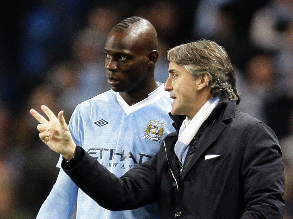 The City manager, Roberto Mancini, says that if Mario Balotelli was his son he would give him 'a kick up the arse' for smoking