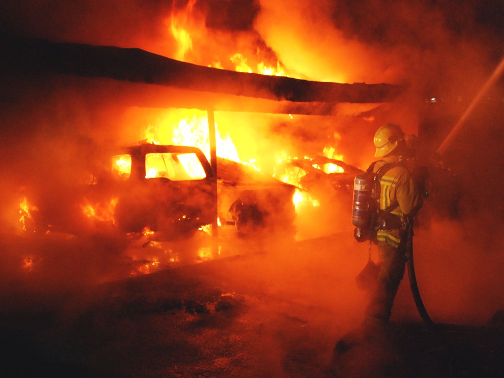 A Los Angeles firefighter tackles a car blaze in West Hollywood