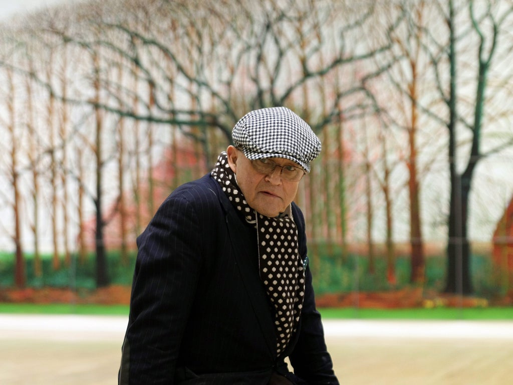 David Hockney poses in front of a photographic copy of his monumental painting ‘Bigger Trees Near Warter’ (2007) at the Tate Britain Gallery