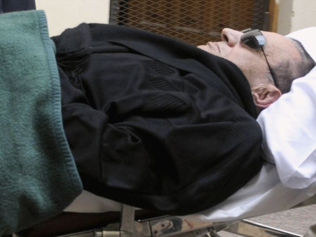 Former Egyptian President Hosni Mubarak lies on a stretcher. He has complained of poor health