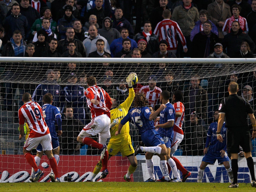 Stoke defender Robert Huth heads his team's third goal during a satisfying win for Tony Pulis against Gillingham at his old stomping ground