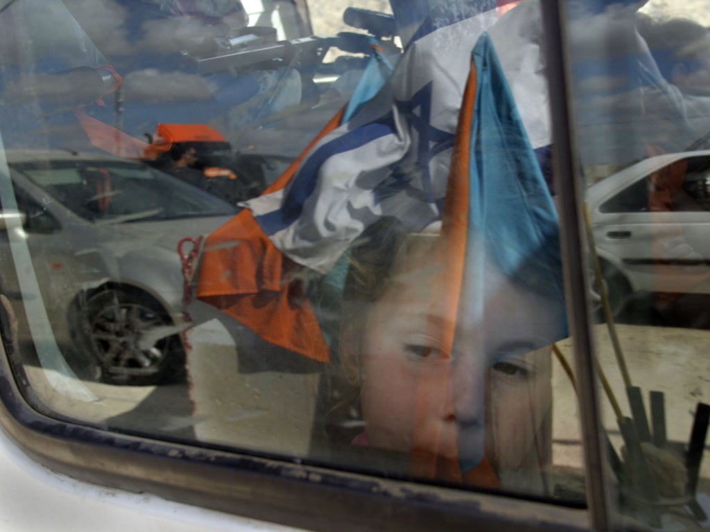 A young girl waits at a checkpoint near Kisufim, Israel - one of many that are choking the economic life of the West Bank