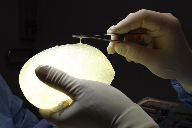 A French plastic surgeon holds one of the defective PIP breast implants removed from a patient a few days before Christmas