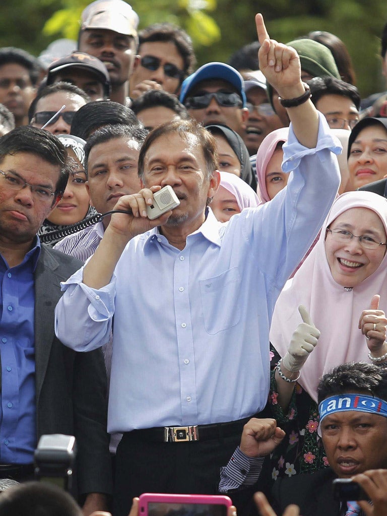Anwar Ibrahim is greeted by thousands of supporters outside the High Court yesterday