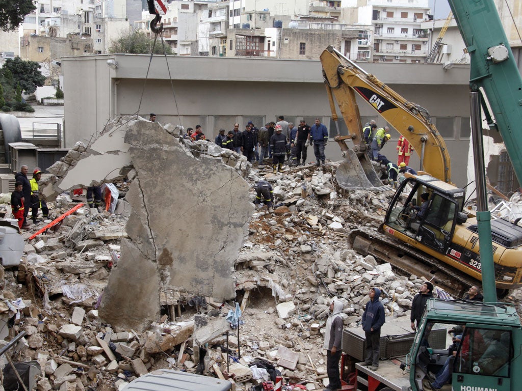 Rescue workers remove rubble at the site of the collapsed building in Beirut