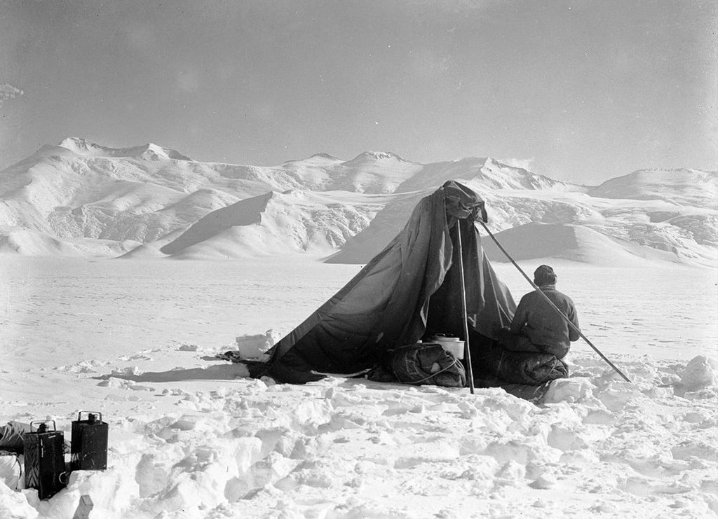 A photograph taken by Captain Scott on his final expedition of Dr Edward Wilson sketching on Beardmore Glacier.