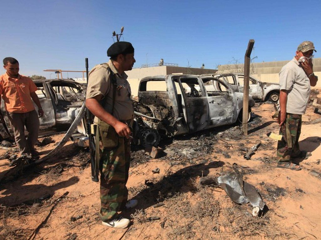 Anti-Gaddafi fighters survey the damage after a Nato airstrike on a
convoy of Gaddafi loyalists in Sirte last October