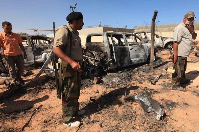 Anti-Gaddafi fighters survey the damage after a Nato airstrike on a
convoy of Gaddafi loyalists in Sirte last October