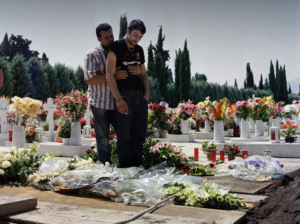 'Marigliano is a town of the living dead',  so said the mother of 21-year-old Andrea Capasso, who died of cancer. Here, Andrea's best friend Amodio is held up by his friend Pasquale,
as he shares in a last smoke by Andrea's grave following a tearful funeral