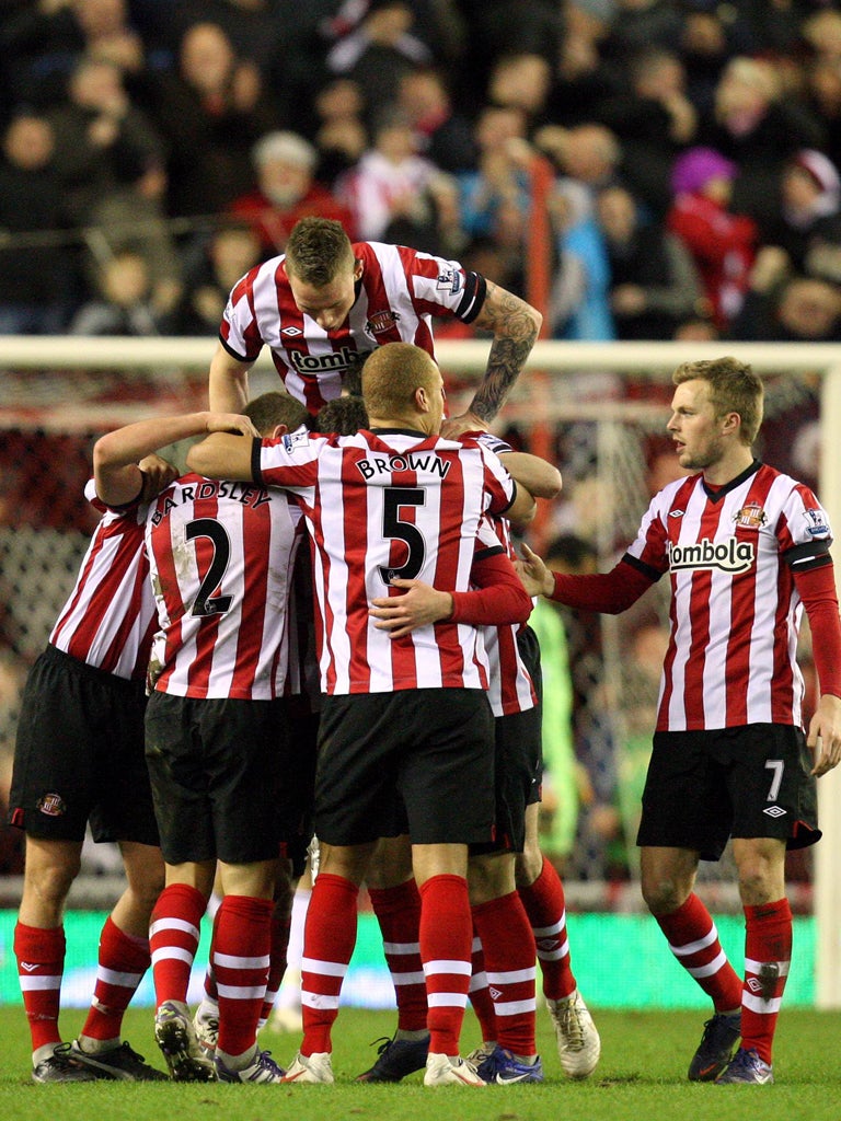 Tower of power: Sunderland’s Craig Gardner is mobbed by team-mates after scoring his side’s second goal in the 2-0 defeat of Swansea City at the Stadium of Light