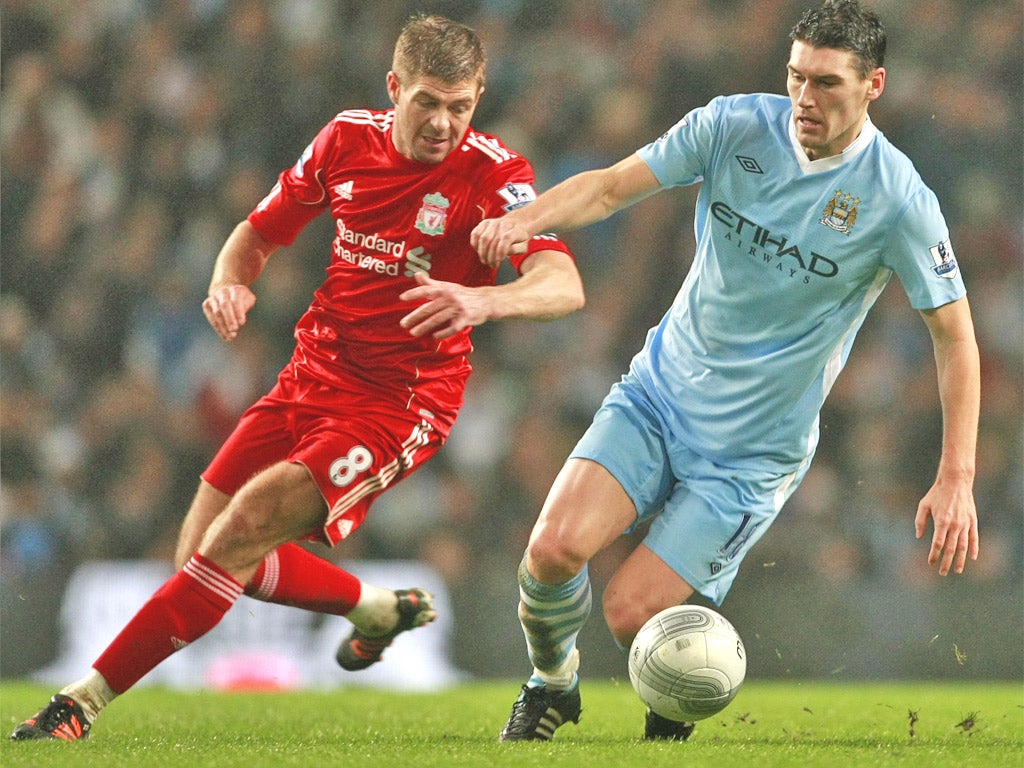 Gerrard and Barry battle for the ball during the first leg encounter