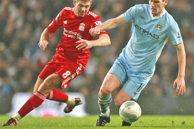 Gerrard and Barry battle for the ball during the first leg encounter