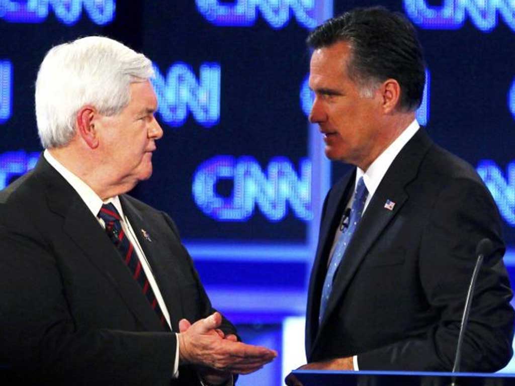 Former Speaker of the House Newt Gingrich (left) talks with Massachusetts Governor Mitt Romney during a break in the Republican presidential candidates debate in Florida