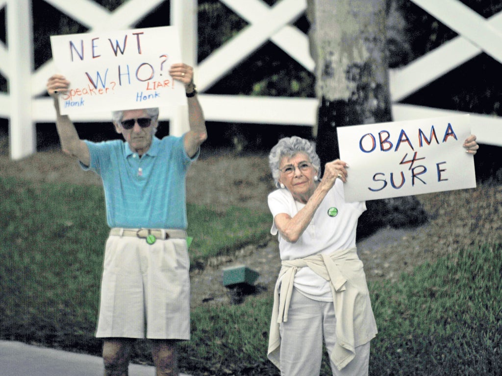 Two Florida residents show their preference for President Obama during a visit by Newt Gingrich