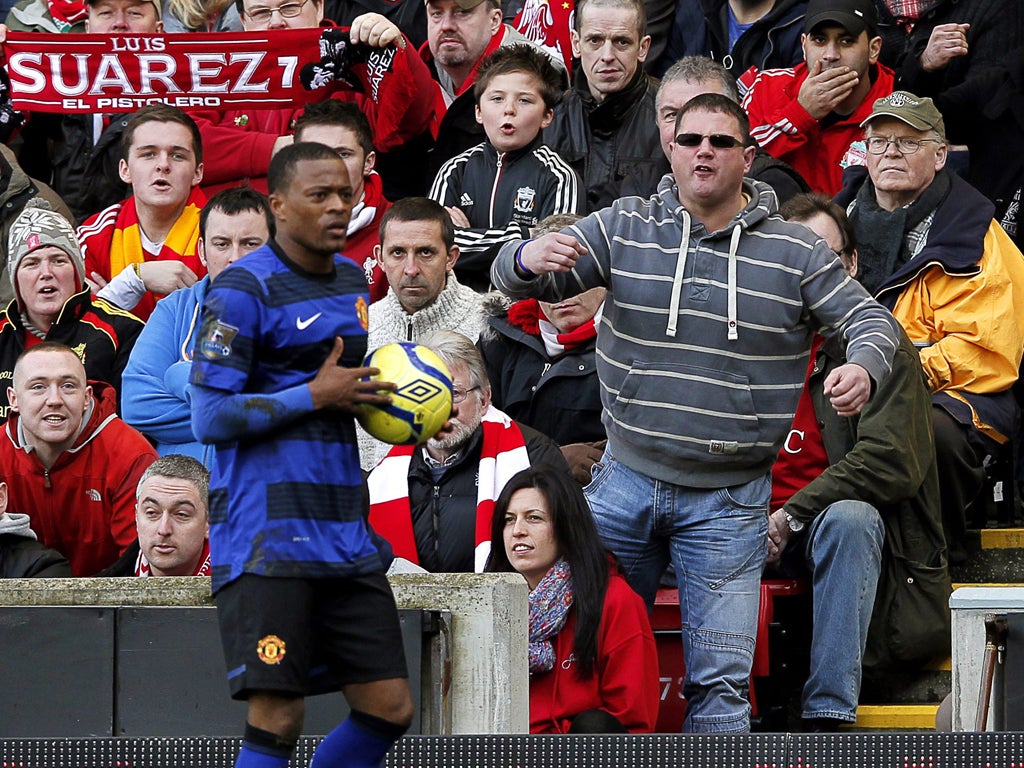 Two’s a crowd: Patrice Evra receives unwelcome attention from a supporter