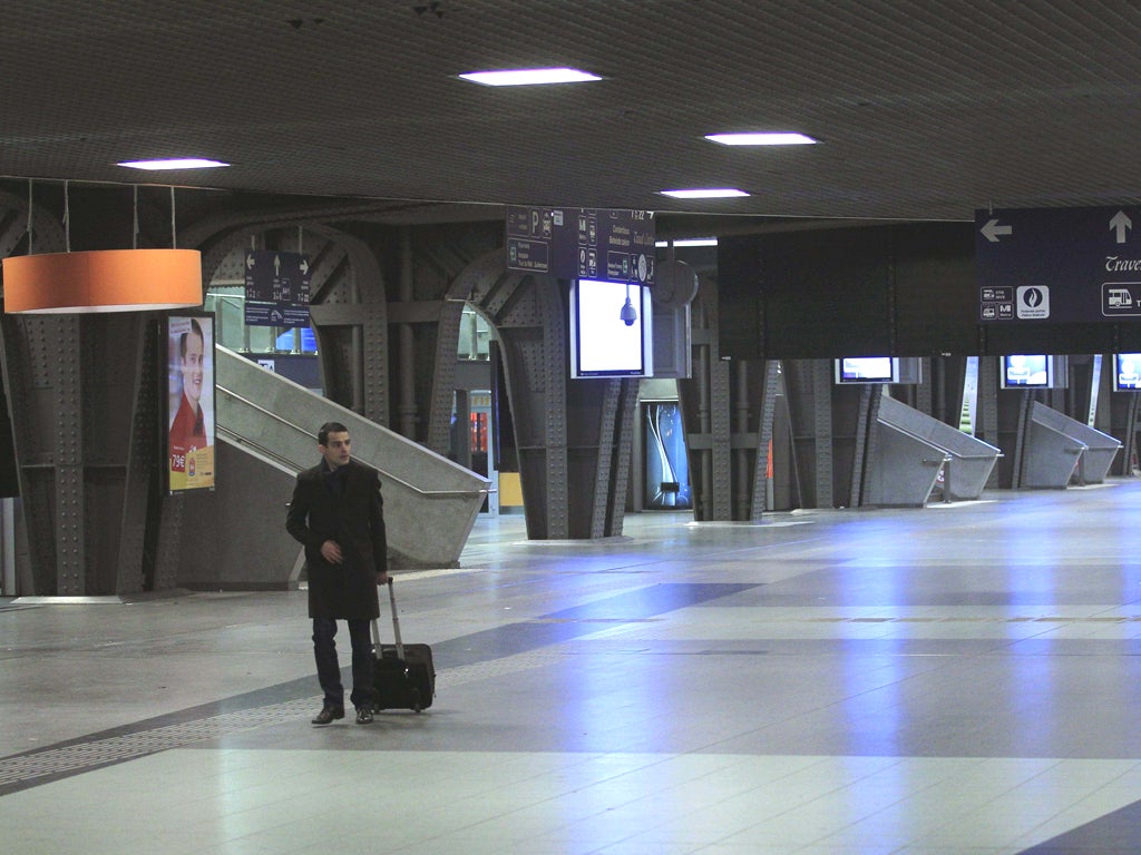 A passenger walks in an empty train station in Brussels during a nationwide strike