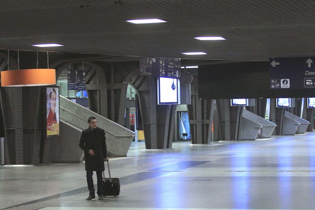 A passenger walks in an empty train station in Brussels during a nationwide strike 
