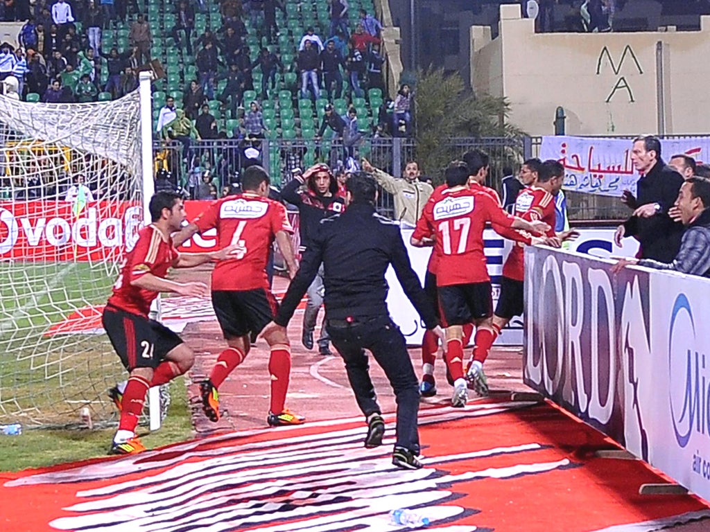 Visiting Al-Ahly players escape from the field after the match in Port Said