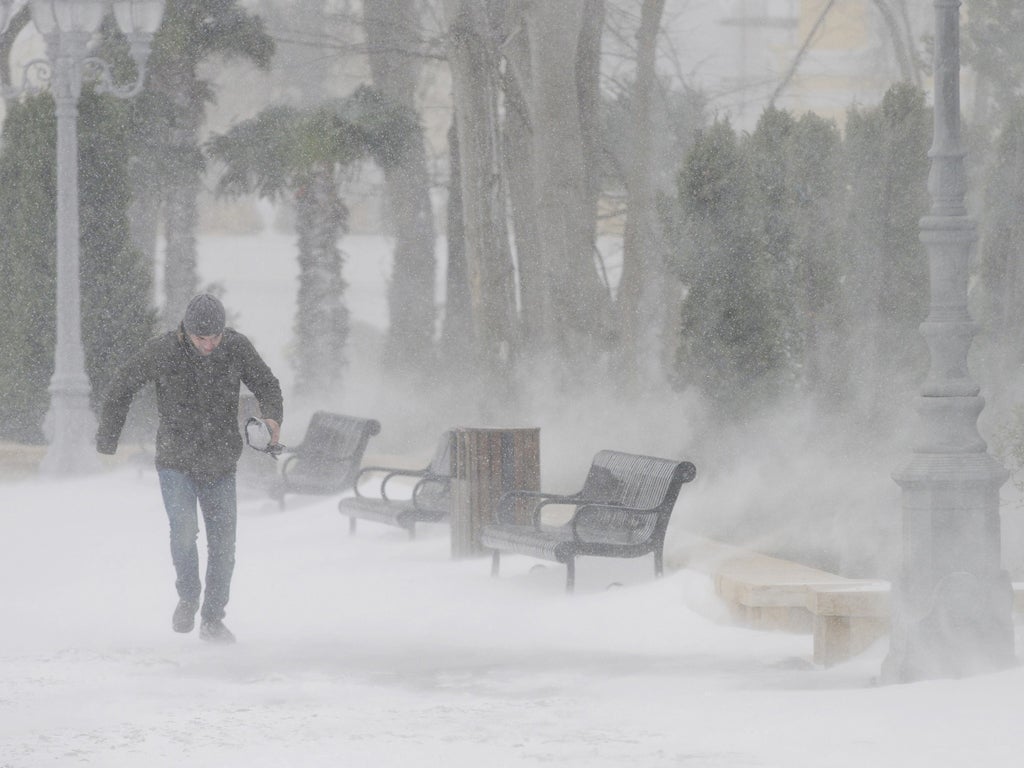 A man walks under heavy snow in Baku, Azerbaijan