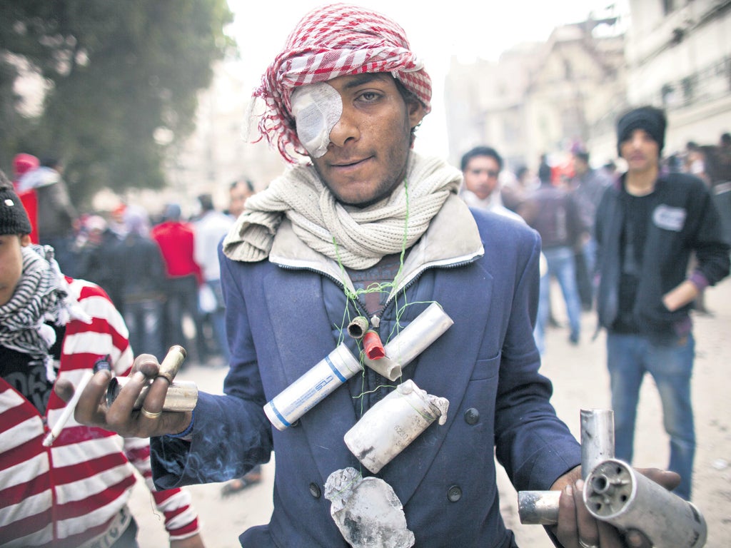 A protester shows tear gas cartridges during clashes between protesters and riot police near the interior ministry