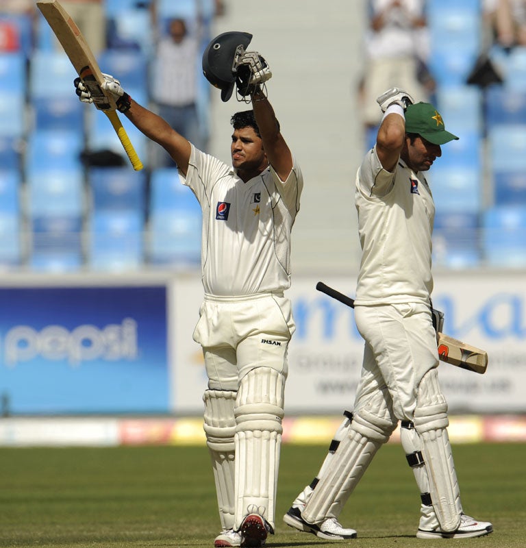Pakistan's Azhar Ali (left) celebrates reaching his century as teammate Misbah-ul-Haq walks away