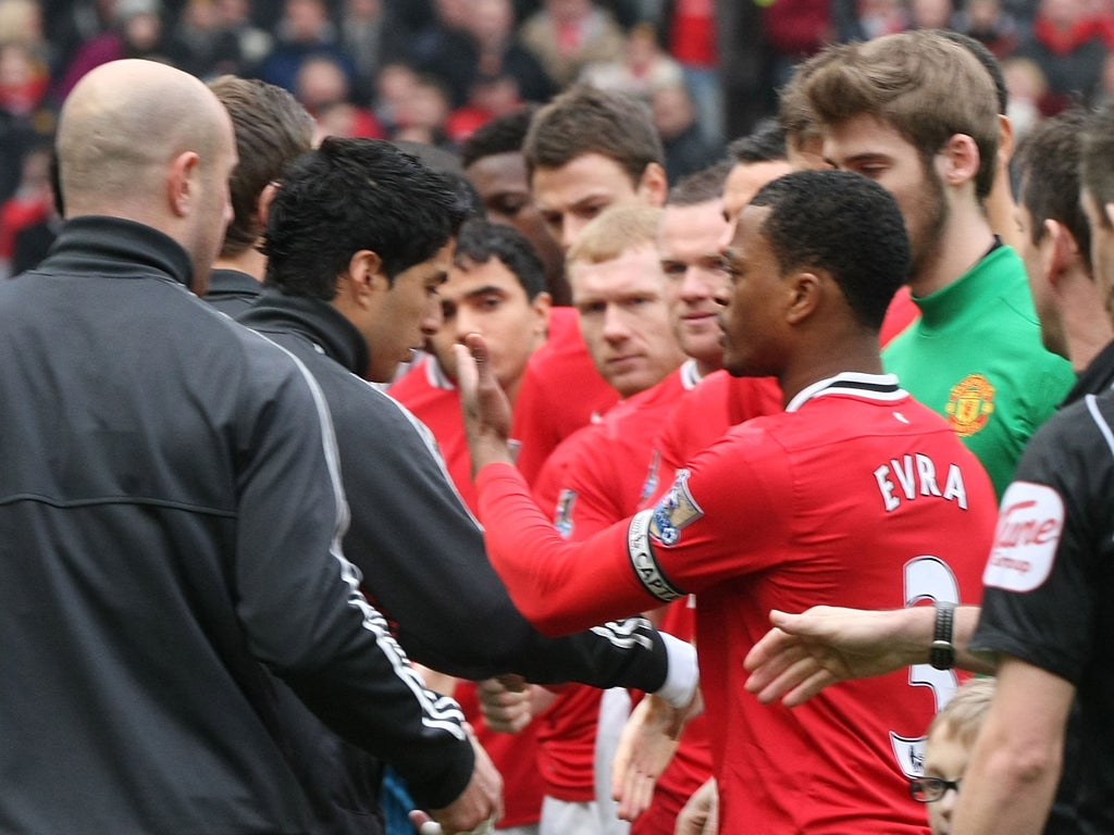 Luis Suarez refuses to shake hands with Patrice Evra at the beginning of the ill-tempered game at Old Trafford