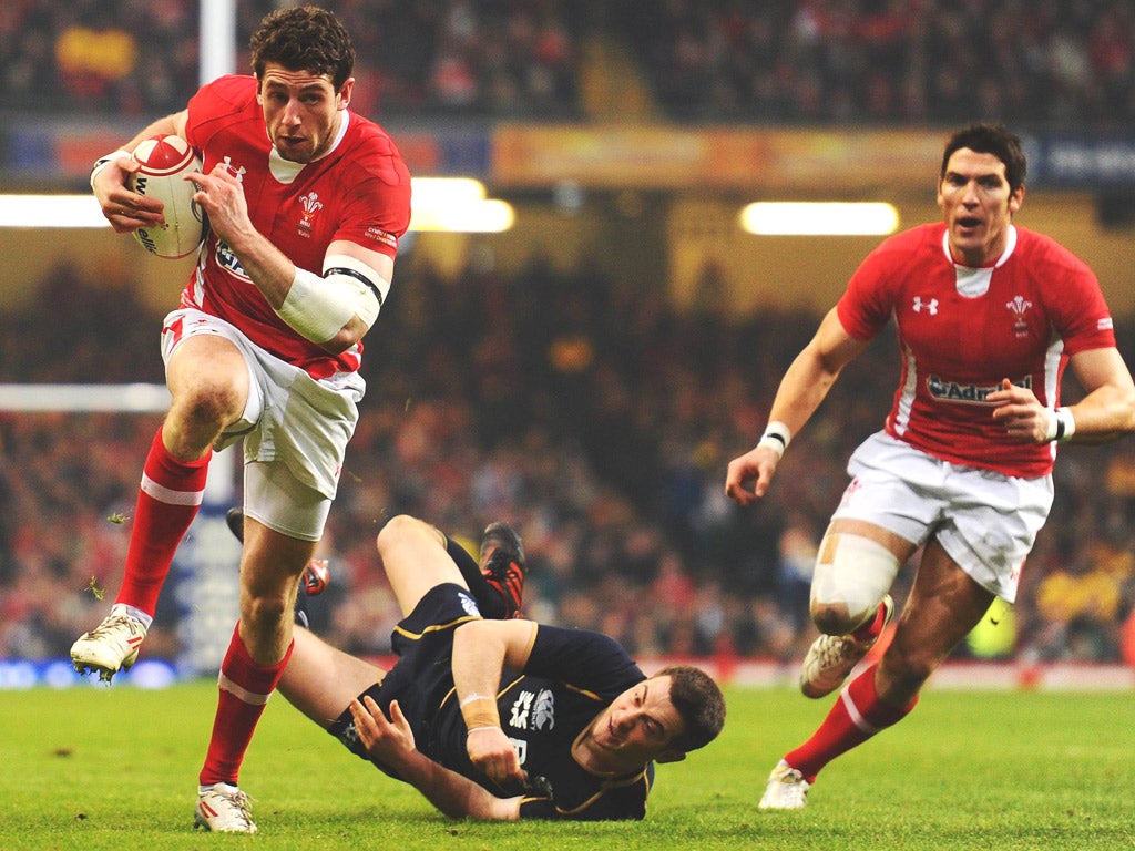 Alex Cuthbert, of Wales, breaks through the Scottish defence to score a try yesterday