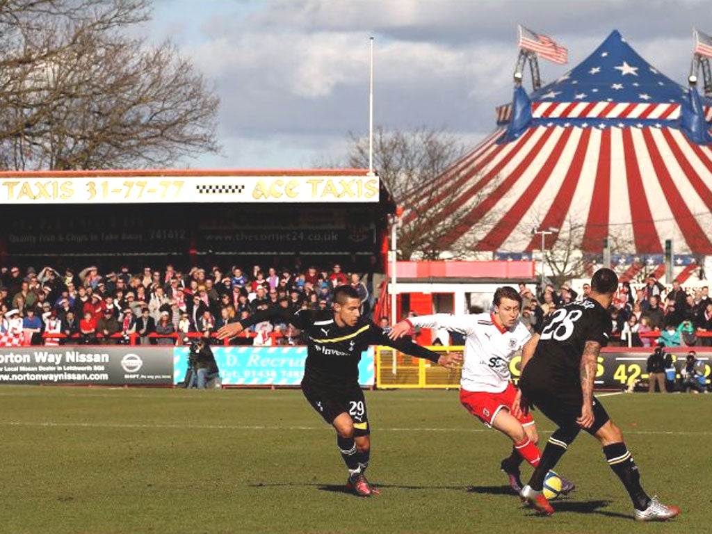 Luke Freeman, of Stevenage, runs at Spurs’ Jake Livermore and Kyle Walker yesterday