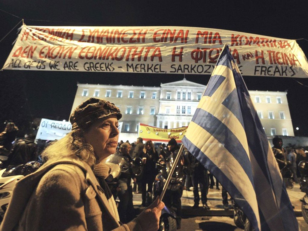 A woman holds a Greek flag as she takes part in an anti-austerity demonstration in Athens last night