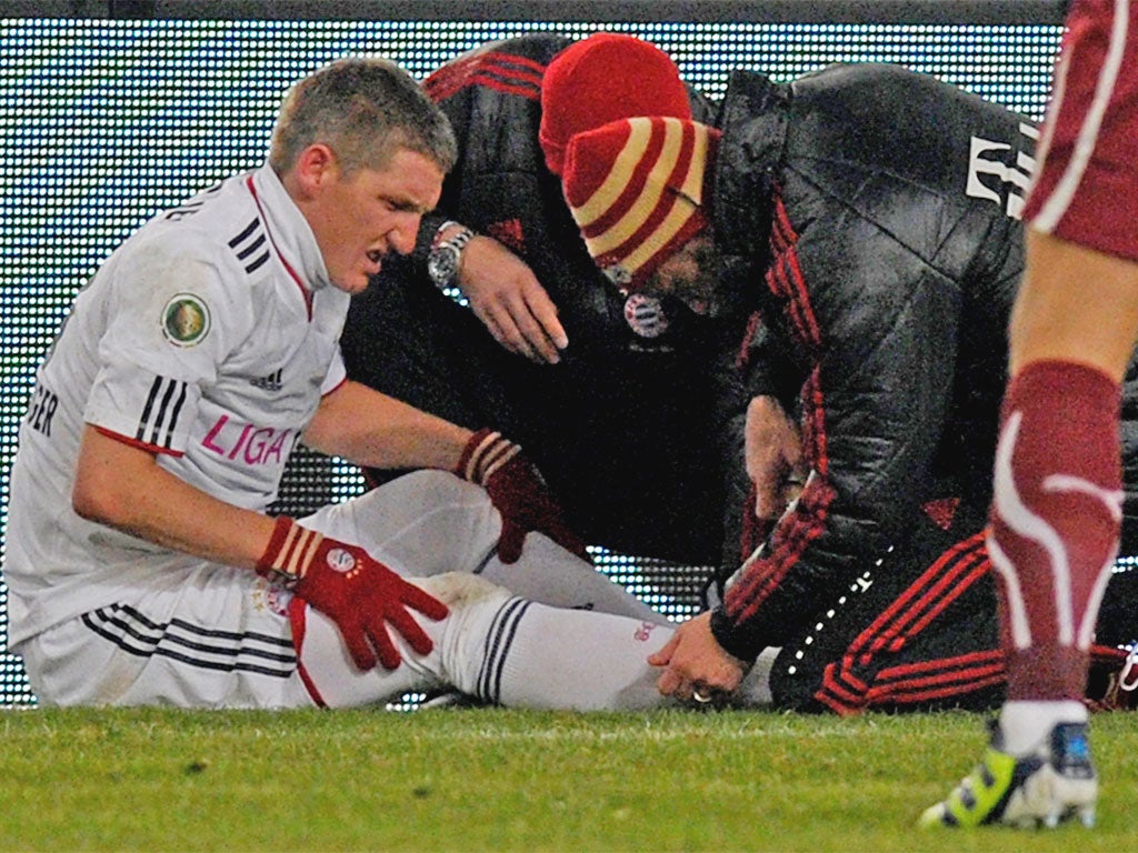 Bastian Schweinsteiger receives treatment after suffering an ankle injury earlier this month