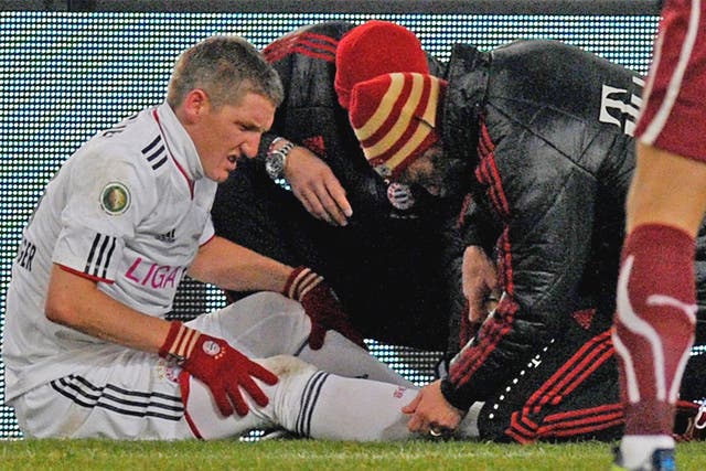Bastian Schweinsteiger receives treatment after suffering an ankle injury earlier this month