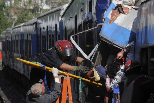 Firemen rescue wounded passengers from a commuter train after a collision in Buenos Aires