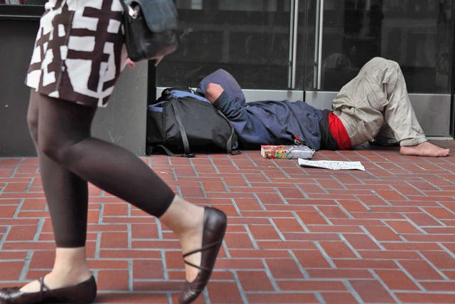 A homeless man sleeps in the street