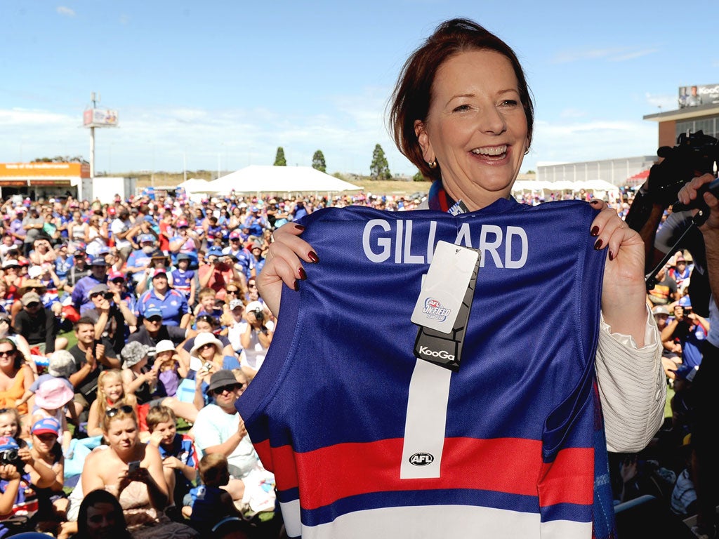 Charm offensive: Prime Minister Julia Gillard poses with the colours of the Australian rules football team Western Bulldogs at the club’s family day in Melbourne