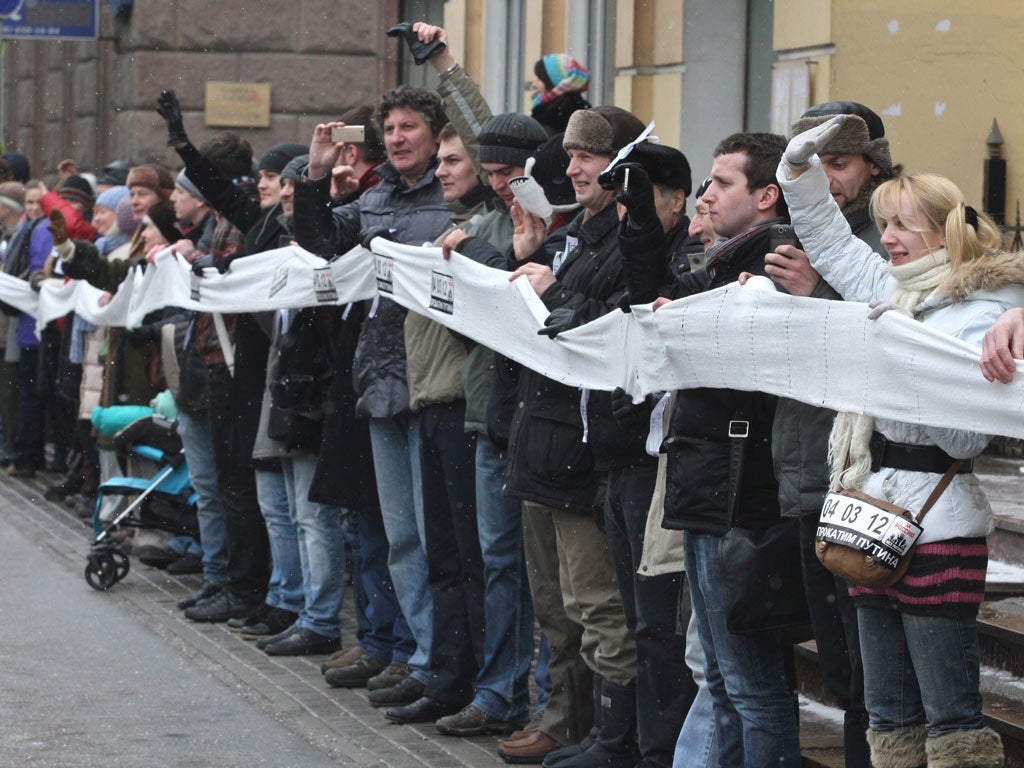 Opposition supporters carry white ribbons during the rally in Moscow