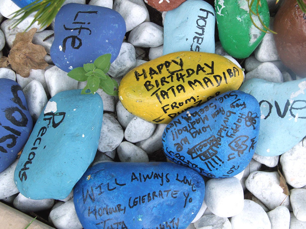 Painted pebbles with messages placed outside Mr Mandela’s home