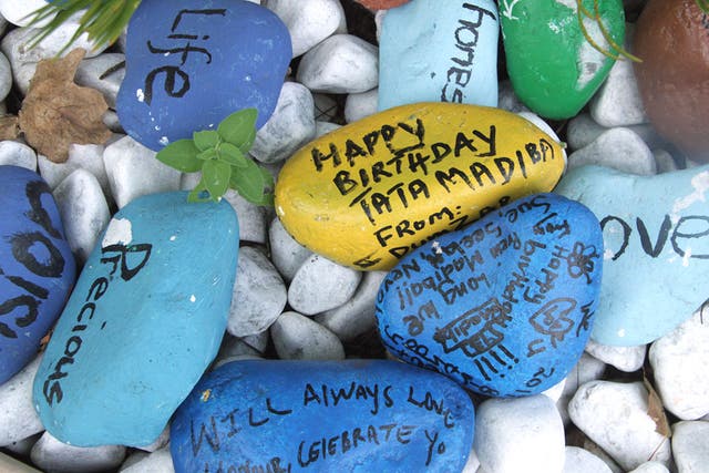 Painted pebbles with messages placed outside Mr Mandela’s home