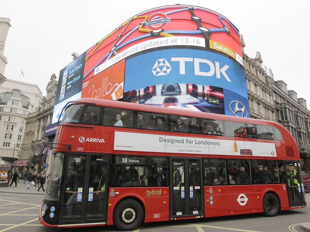 A new routemaster double decker bus passes Piccadilly Circus in London on its first first day of service