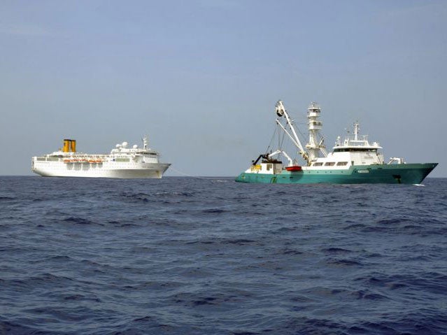 The Costa Allegra (left) is towed by a French fishing boat
