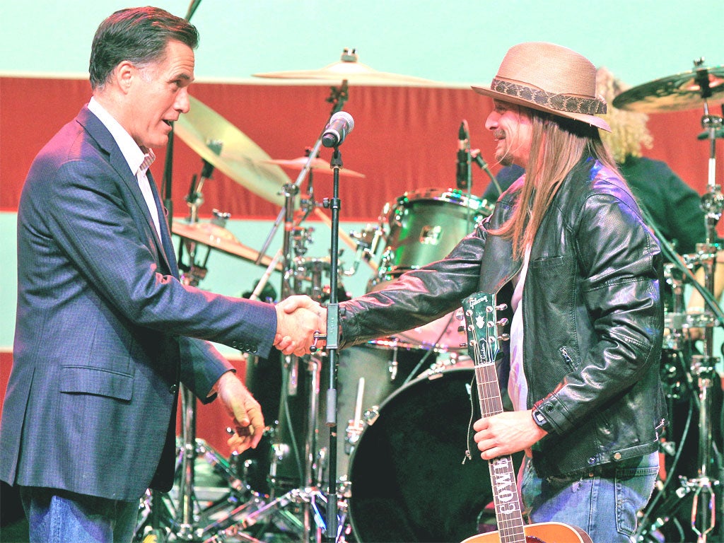 Mitt Romney shakes hands with the musician Kid Rock at a campaign event in Royal Oak, Michigan