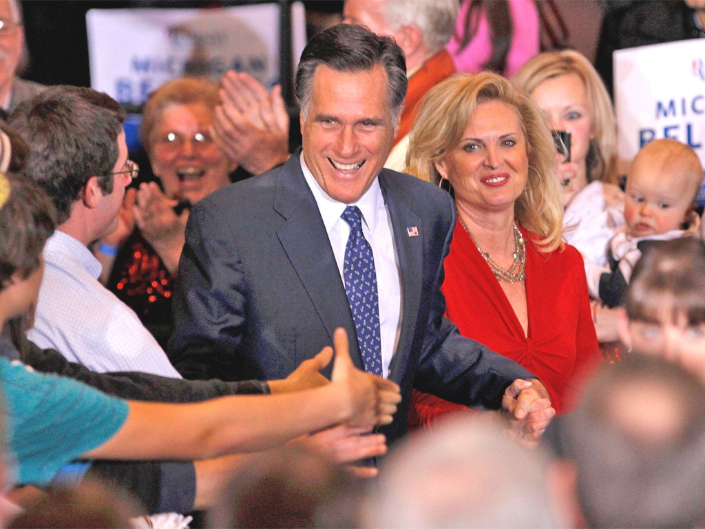Mitt Romney, with his wife Ann, shakes hands with supporters in Novi, Michigan
